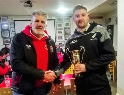 Simon Edwards presents the KO Carpets trophy to George Williams